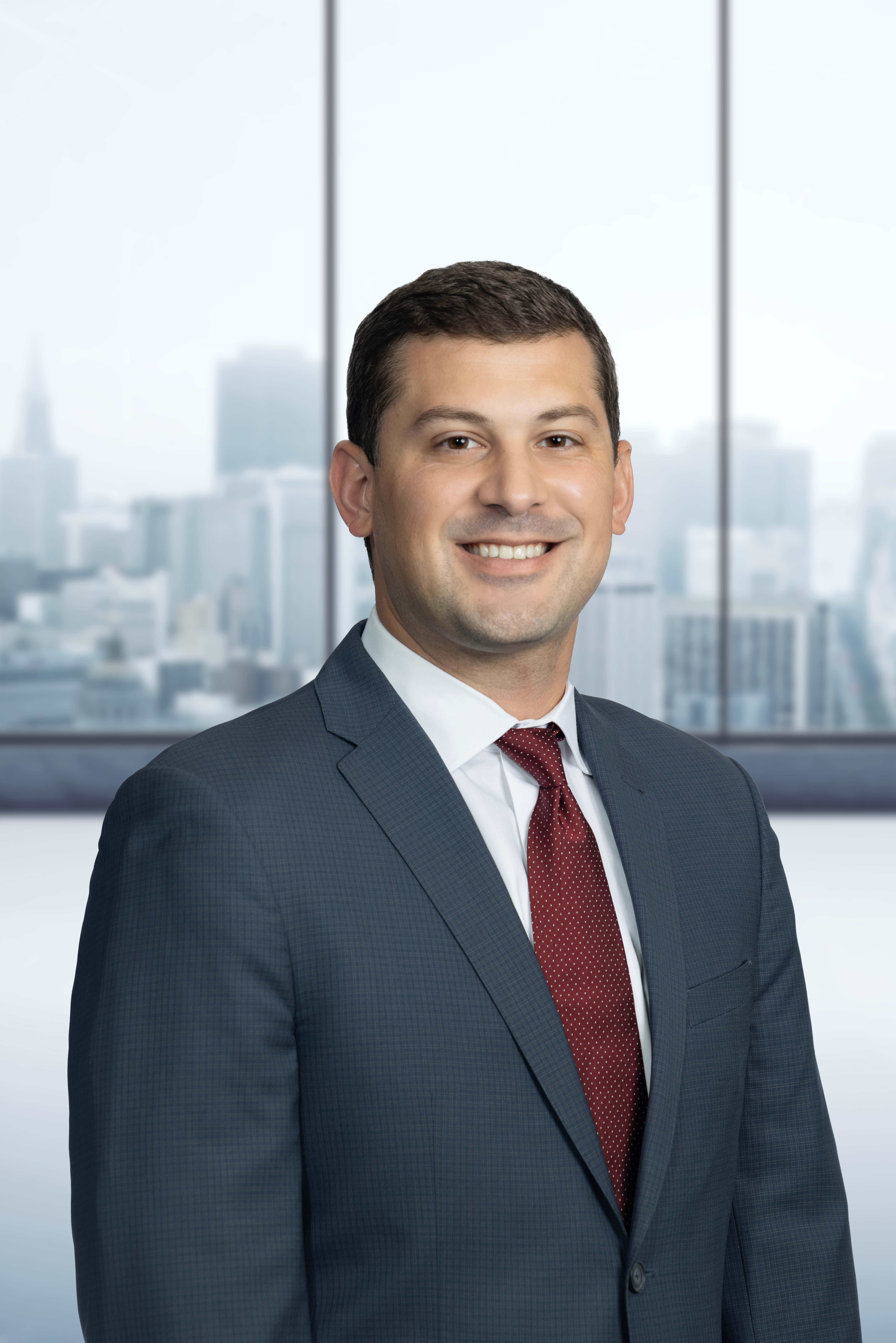 Headshot of Joshua DeBarba before a conference room backdrop.